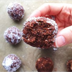 a person holding a chocolate cookie in their hand