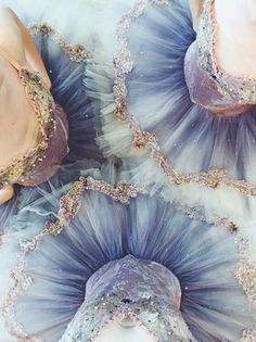 three women in blue and purple dresses with sequins on them