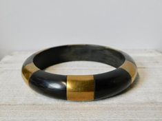 Vintage Black Horn and Brass Bangle Bracelet.unmarked.ca 1970s-1980s.It is 2- 1/2" across the opening and 5/8" W.Normal wear but no damage found.Great condition. Vintage Black Cuff Bracelet As Gift, Vintage Black Bangle Cuff Bracelet, Vintage Black Bangle As Gift, Vintage Black Bangle, Brass Bangle, Bangle Bracelet, Horn, Vintage Black, Bangle Bracelets