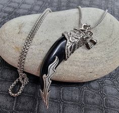 The Fenrir Wolf Necklace for Men features a Viking wolf head design, making it a striking piece of Celtic jewellery and a powerful Viking amulet inspired by Norse mythology. This Fenrir mythical necklace is an ideal gift for anyone who appreciates unique and meaningful accessories. 𝙋𝙧𝙤𝙙𝙪𝙘𝙩 𝙄𝙣𝙛𝙤𝙢𝙖𝙩𝙞𝙤𝙣 🔸Pendant:  6cm x 2cm  🔸Necklace: 24" in length 🔸Hyper allergenic 🔸Norse Mythology 𝙅𝙚𝙬𝙚𝙡𝙡𝙚𝙧𝙮 𝘾𝙖𝙧𝙚 Please minimize contact with harsh chemicals and liquids. 𝙃𝙤𝙬 𝙏 Black Wolf Design Jewelry For Gift, Mythical Necklace, Viking Amulet, Goth Pendant, Norse Necklace, Celtic Jewellery, Fenrir Wolf, Vampire Earrings, Thor's Hammer Necklace