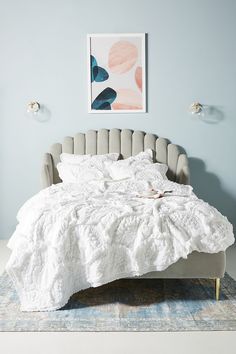 a white bed sitting in a bedroom on top of a rug