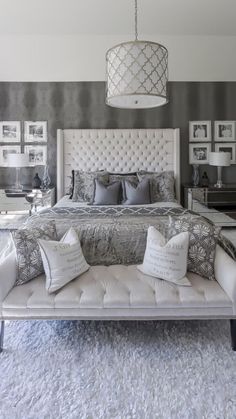 an image of a bedroom with grey and white decor on the walls, bedding and pillows