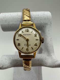 "Elevate her style with the Vintage 22mm Rotary Gold Tone Ladies Swiss Mechanical Wind Dress Cocktail Watch - a stunning piece that transcends time. Adorned with ornate fashion, this watch is a thoughtful gift for her. In good used condition, it runs seamlessly, embodying both charm and reliability. With a fit designed for a 5 3/4\" wrist, it can stretch comfortably to 6\". Embrace the ritual of daily winding, adding a personal touch to each day. Gift her this Rotary timepiece, a perfect fusion of Swiss craftsmanship, vintage elegance, and the joy of timeless tradition. Please message me with any questions" Victorian Gold Watch For Formal Occasions, Victorian Gold Formal Watch, Adjustable Gold Jewelry And Watches With Round Dial, Elegant Gold Engraved Watches, Vintage Formal Watches With Rotating Bezel, Victorian Gold Watch For Weddings, Gold Victorian Watches For Weddings, Elegant Gold Self-winding Watches, Vintage Gold Watch With Round Dial