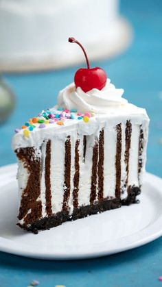 a piece of cake with white frosting and sprinkles on it sitting on a plate