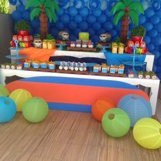 a table topped with lots of different colored balls and paper lantern lanterns on top of it