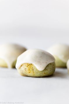 several cookies with white frosting on top of each one sitting in front of the other