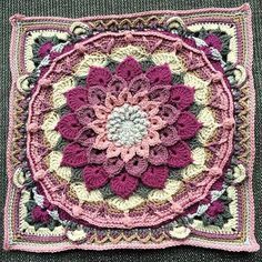 a crocheted square with a flower on it