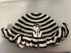 This beautiful black and white striped hat is handmade with love! Crocheted with a ruffle brim and featuring manga appliqué! This hat is big hair/head friendly and is the perfect addition to any outfit! Playful Handmade Black Hats, Cute Black Hats For Spring, Cute Adjustable Black Crochet Hat, Adjustable White Hat With Ruffles, Adjustable White Ruffled Hat, Adjustable White Ruffle Hat, Crochet Ruffle Hat, Ruffle Hat, Striped Hat