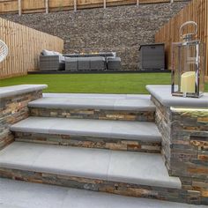 an outdoor patio with stone steps and grass