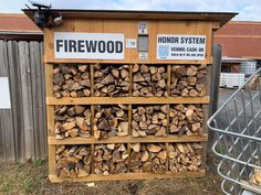 there is a firewood rack in front of a fenced off area with many logs stacked on it