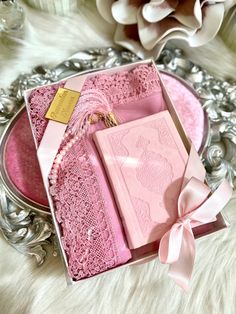 a pink box with a ribbon and some cards in it