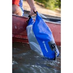 a person holding onto a blue bag in the water