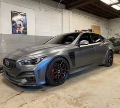 a silver car parked in a garage next to another car