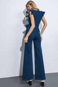 Denim jumpsuit featuring v-neckline, ruffled sleeve, front zipper closure, self sash tie & flare leg. 75% Cotton, 23% Polyester, 2% Spandex Chic Denim Belted Jumpsuits And Rompers, Fitted Wide Leg Jumpsuits And Rompers With Belt, Denim Jumpsuits And Rompers With Ruffles, Chic Denim Jumpsuit With Ruffles For Spring, Spring Fitted Denim Jumpsuit With Belt, Fitted Belted Denim Jumpsuit For Spring, Belted Fitted Denim Jumpsuit For Spring, Ruffle Jumpsuit, Denim Jumpsuit