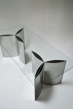 a glass and metal table with curves on it