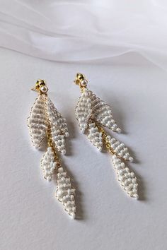 Delicate, Handmade ALAYA Wedding Earrings Dreaming of unique jewelry for your wedding? Our handmade earrings are the perfect choice!  Crafted from high-quality materials: gold-plated wire, pearly seed beads, and hypoallergenic stainless steel studs, they will enchant you with their delicate beauty.  Thanks to the two-part design, you can wear them both long and short, adapting them to any style. Ideal for weddings, but also for many other occasions. Earrings measurement: * Full length: approx 8cm (3.15") * Short part length: approx 3.3cm (1.3") Matching Items:   See Other EARRINGS: https://www.etsy.com/shop/martalilyjewellery/?etsrc=sdt&fbclid=PAZXh0bgNhZW0CMTEAAabSJ6QrVgLVFeGJhsEoqw9viOlBSQ6EGWor-p_Zyv4UQ0idJ2NciFsHfdg_aem_SD41An-A-HJk9DPh-CSeDQ&section_id=40157901 CARING FOR GOLD-PLATED Beaded Wedding Earrings, Minimalist Wedding Earrings, Wedding Drop Earrings, Wedding Earrings Drop, Delicate Beauty, Beaded Wedding, Earrings Minimalist, Stunning Earrings, Minimalist Wedding