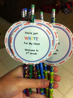 someone is holding up some colorful crayons with writing on the front and back