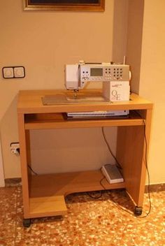 a sewing machine sitting on top of a wooden table next to a wall mounted clock