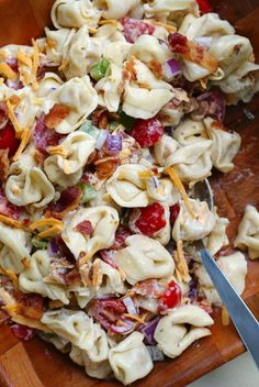 a wooden cutting board topped with pasta salad