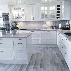 a kitchen with white cabinets and wood floors