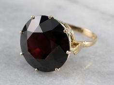 With it's striking color and ornate filigree, there is nothing subtle about this ring! This high fashion piece is bold and eye-catching. We've set it with a stone worthy of its character: a garnet with a deep, blood red color and glittering flash that seems to come from deep within the stone. Metal: 14K Yellow Gold Gem: Garnet 30.23 Carats Gem Measurements: 18.8 mm, Round Ring Size: 8 Marks: "14K" Stamped on the inside band Formal Filigree Garnet Ring With Gemstone, Formal Garnet Filigree Ring With Gemstone, Aquamarine Cocktail Ring, Blood Red Color, Pyrope Garnet, Demantoid Garnet, Garnet And Gold, Garnet Gem, Gold Cocktail Ring