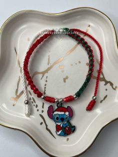 the bracelet is decorated with an elephant and a red string that has a charm on it