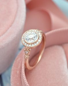 a close up of a diamond ring on pink velvet