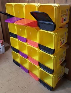 a large stack of yellow and purple bins on top of each other in a room