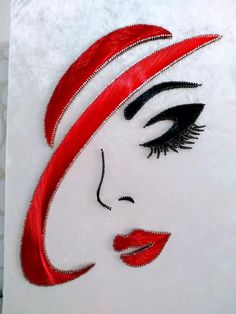 a woman's face with red hair and black eyelashes on a white background, made out of paper