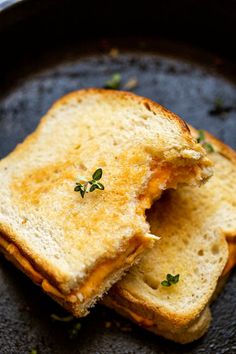 two pieces of bread that have been grilled together in a skillet with some parsley on top