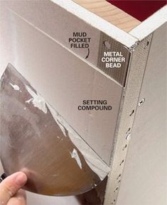 a hand is opening the door to a metal cabinet with instructions on how to install it