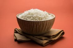 a bowl filled with white rice sitting on top of a table next to napkins