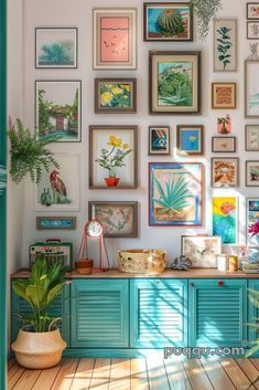 a room filled with lots of framed pictures and potted plants on top of a wooden table