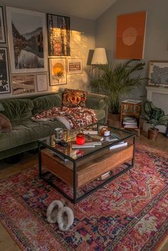 a living room with green couches and pictures on the wall above it, along with rugs