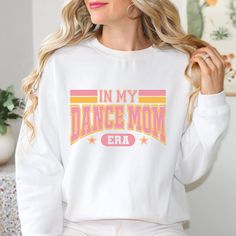 Rock the sidelines with this super comfy In My Dance Mom Era Women's Sweatshirt. This varsity-style sweatshirt not only shows off your pride for your dancer, but also keeps you cozy during those early morning practices. Perfect for the fun-loving dance mom who doesn't take herself too seriously!Fleece crewneck unisex sweatshirt. 50% US Cotton / 50% Polyester.COLORS MAY APPEAR SLIGHTLY DIFFERENT FROM YOUR MONITOR TO THE ACTUAL FABRIC. Varsity Style, Mom Era, Dance Mom, Style Sweatshirt, Fun Loving, Dance Moms, Early Morning, Large White, Unisex Sweatshirt