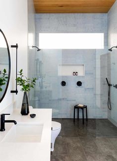 a white bathroom with two sinks and a shower