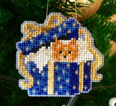 a cross stitch ornament hanging from a christmas tree