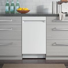 a white dishwasher sitting on top of a kitchen counter next to a bowl of lemons