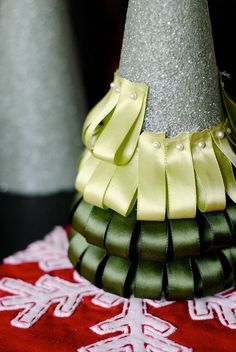 a green and yellow hat on top of a red table cloth with silver sequins