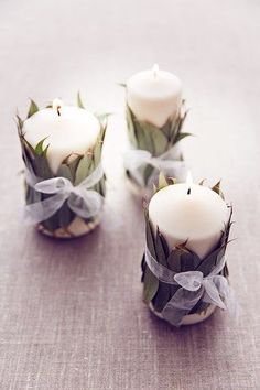 three white candles sitting on top of a table