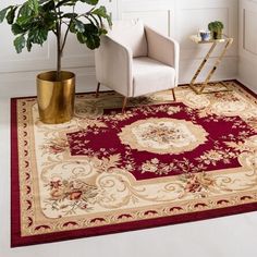 a living room area with a chair, rug and potted plant on the floor