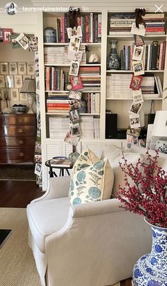 a living room filled with furniture and bookshelves covered in pictures on the wall