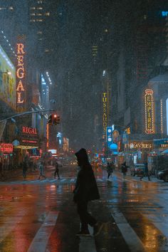 people crossing the street in the rain at night