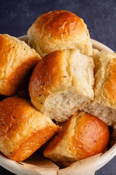 a bowl filled with rolls sitting on top of a table