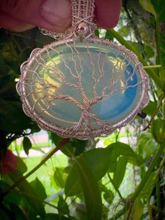 Silver Moonstone (Opalite) tree of life pendant, Wire wrap family Tree necklace, Tree of life pendant, Double sided pendant  Material: silver plated wire Details:  Pendant dimension:  2,5 x 2 inch Chain length: 24 inch Color: blue This beautiful Tree of Life necklace is hand-crafted unisex necklace with Opalite  and Silver plated wire. Opalite is a milky man-made stone of translucent glass and crushed opals. It can transform from a rainbow sheer to a bright blue to flashy yellow depending on the light. The pendant in the photos was shot in natural sunlight Tree of Life symbol crosses all cultures and stems back to our ancient ancestors. It represents wisdom, strength, prosperity, protection, beauty and connection to our Earth. This pendant made with good intentions and love! One of a kind, Tree Of Life Symbol, Necklace Tree, Family Tree Necklace, Translucent Glass, Life Symbol, Tree Necklace, Unisex Necklace, Tree Of Life Necklace, Tree Of Life Pendant