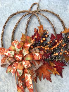 a wreath with fall leaves and berries on it