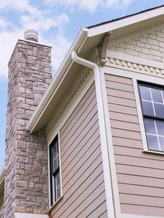 a fire hydrant on the side of a house next to a brick chimney and window