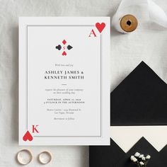 a wedding card with playing cards on it next to some flowers and other items that include rings