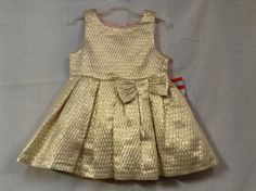 One of the cutest little dresses for a 12 month size child. Cute little bow at waist . Buttons in back. Crinoline underneath with pink polyester against skin. Has its own little pink matching panties to go over the diaper.  It is just so cute. Elegant Spring Holiday Dress For Fancy Events, Gold Summer Dress For Dress-up, Gold Dresses For Summer Dress-up, Fitted Spring Holiday Dress For Fancy Occasions, Spring Gold Party Dress, Cute Gold Party Dress, Fitted Holiday Dress For Spring Festivities, Metallic Party, Little Dresses