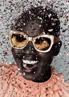 a woman with glasses and confetti all over her face